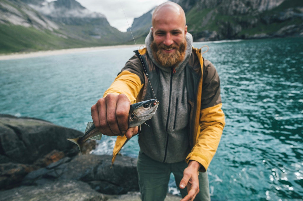 Angler smiling while holding a freshly caught fish during a fly fishing trip