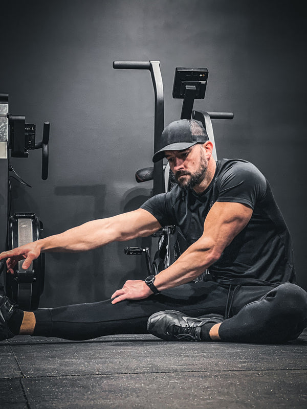 Man stretching in gym wear for fitness.