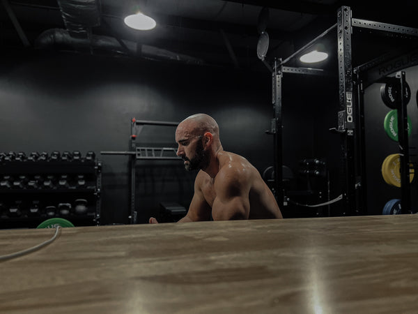 Man reflecting post-workout in gym setting